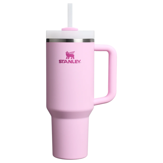 Pink Stanley tumbler with a handle on a white background