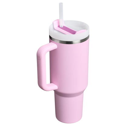 Pink tumbler with a handle and straw on a white background